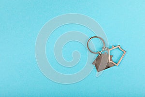 Keychain in the shape of a house with a key ring on background.