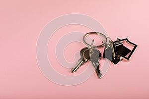 Keychain in the shape of a house with a key ring on background.