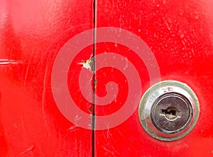 The keyhole is contrasted with the red color of the postbox.