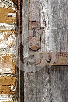 Keyhole in an old paneled wooden door; rusty and weathered. This