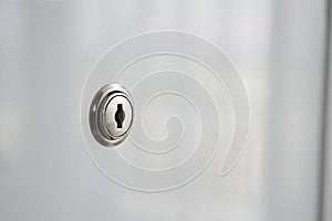Keyhole of white acrylic material surface desk drawer background. Concept for security information or keep secret use for business