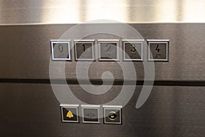 Keypad of a modern elevator decorated in gray polished aluminum