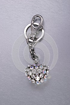 Keyring heart with sparkeling gem stones on steel background