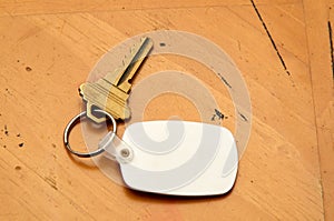 Keyring with key and white fob on wood table