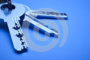 Keyring with keys in blue tone over an empty background