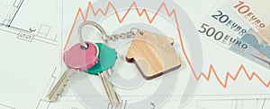 Keys, euro and downward graphs representing crisis of real estate market. Reduced housing prices