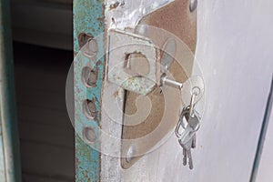 Keys, forgotten in keyhole of metal door with powerful overhead lock