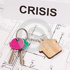 Keys with house shape and inscription crisis on housing plan. Crisis of real estate market. Reduced housing prices