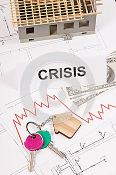 Keys, inscription crisis, dollars and downward graphs representing crisis of real estate market. Reduced housing prices. House