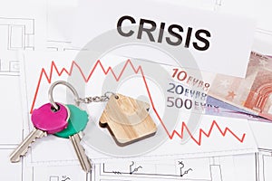 Keys, inscription crisis, euro and downward graphs representing crisis of real estate market. Reduced housing prices