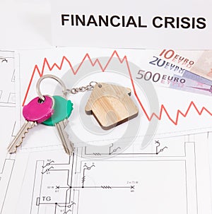 Keys, inscription financial crisis, euro and downward graphs representing crisis of real estate market. Reduced housing prices