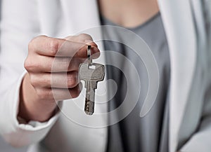 Keys on keyring held bu female hand close up. Home owner giving doorkeys