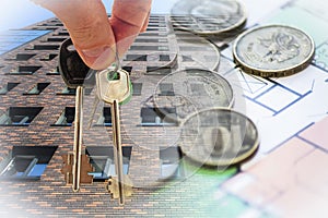 The keys to the apartment in the background of the facade of the house and money .