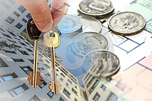 The keys to the apartment in the background of the facade of the house and money .