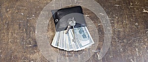 The keys to the apartment on the wallet with banknotes