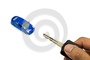 Right hand holding car key and car model for business concept