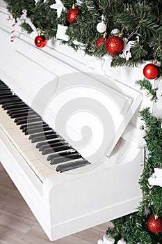 Keys on white upright piano with christmas decor