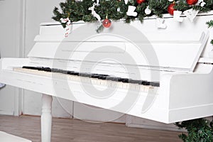 Keys on white upright piano with christmas decor