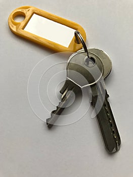 Keys with yellow key ring with blank tag. White background