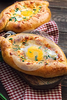 Khachapuri Ajarian on rustic wooden background