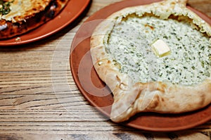 Khachapuri Made From a Delicious Tender Dough with Spinach, Melted Cheese and Butter Close Up. Traditional Hachapuri