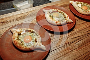 Khachapuri Made From a Delicious Tender Dough with Spinach, Melted Cheese and Butter Close Up. Traditional Hachapuri Topped with