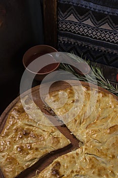 Khachapuri with meat on a wooden background