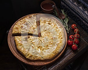 Khachapuri with meat on a wooden background