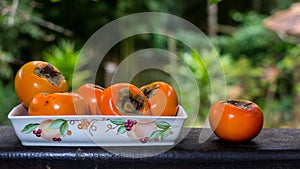 Khaki in ceramic bowl against tropical background photo