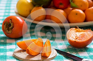 Khaki fruit slices on a table and knife photo