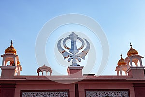 Khanda sikh holy religious symbol at gurudwara entrance with bright blue sky