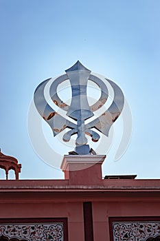 Khanda sikh holy religious symbol at gurudwara entrance with bright blue sky