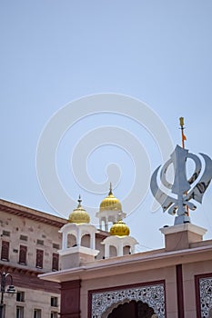 Khanda Sikh holy religious symbol at gurudwara entrance with bright blue sky image is taken at Sis Ganj Sahib Gurudwara in Chandni