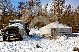 Khanh, Mongolia, Febrary, 24, 2018. Old wooden house in winter Mongolia near forest with old big russian track