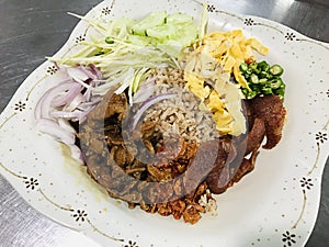 Khao kluk kapi or Fried rice with shrimp paste served with sweetened pork belly in Thailand.