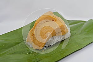 Khao niao sangkhaya or sticky rice with coconut custard with banana leaves, unwrapped, a delicious Thai dessert