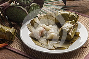 Khao tom mad Thai food style dessert, made from banana and glutinous rice, wrap with banana leaf on wooden table