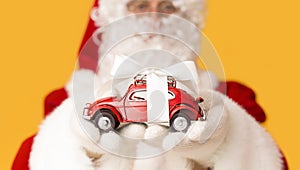 Blurred Santa Claus suggesting toy car Volkswagen Beetle with present bow