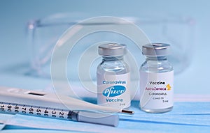 Kharkiv. Ukraine. February 1, 2021. Coronavirus vaccine vials with AstraZeneca logo and with Pfizer logo , syringe, mask,