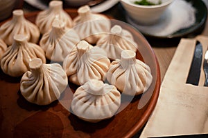 Khinkali is a dish of Georgian cuisine. Food on a plate. Boiled dough with filling. Dumplings. Lunch is on the table. A