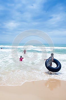 Khmer teenage girls playing in the waves on the Ochheuteal Beach in a rainy day