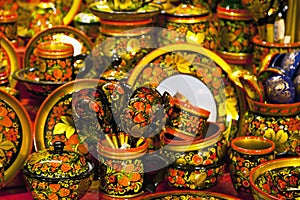 Khokhloma utensils. Kitchen tableware in Russian folk style. Wooden spoons and bowls in bright red, yellow, golden colors.