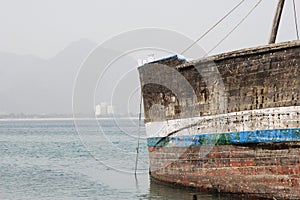 Khor Fakkan UAE old wooden dhow washed up on shore in front of Khor Fakkport