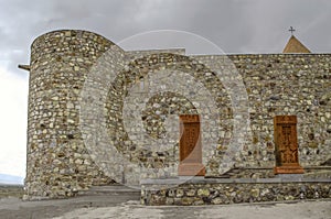 Khor Virap fortress and the outer corner with a round tower with khachkars at the wall and a view of the dome of the Church Holy m