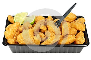 Kibbeling in a plastic tray isolated on white background.