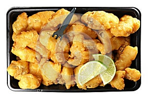 Kibbeling in a plastic tray isolated on white background.