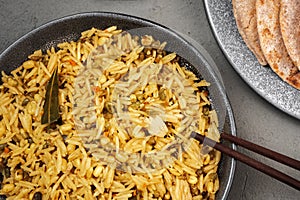 Kichari in a gray plate with Khasi sticks on a concrete surface close - up view from above