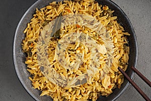 Kichari in a gray plate with Khasi sticks on a concrete surface close - up view from above