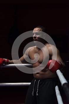 Kick boxer resting on the ropes in the corner