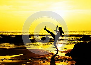 Kick boxing young woman on the beach photo